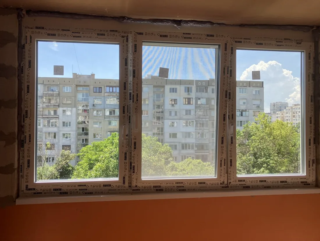 Показани са три нови пластмасови прозореца с изглед към жилищна сграда.
