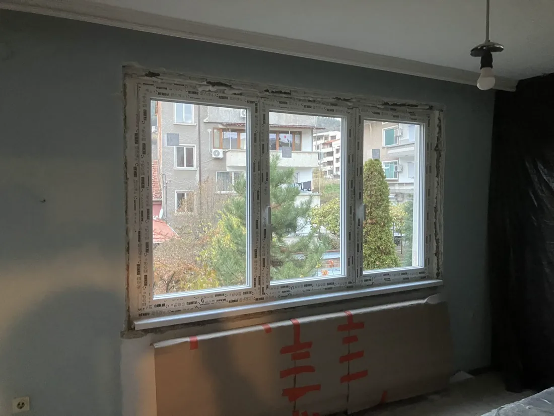 Инсталирано PVC прозорец с декоративен рамка в апартамент.